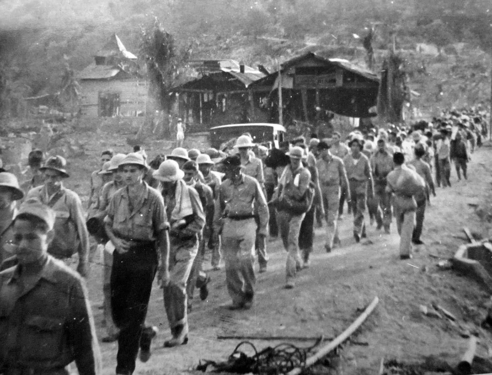 Photo of men marching through rubble