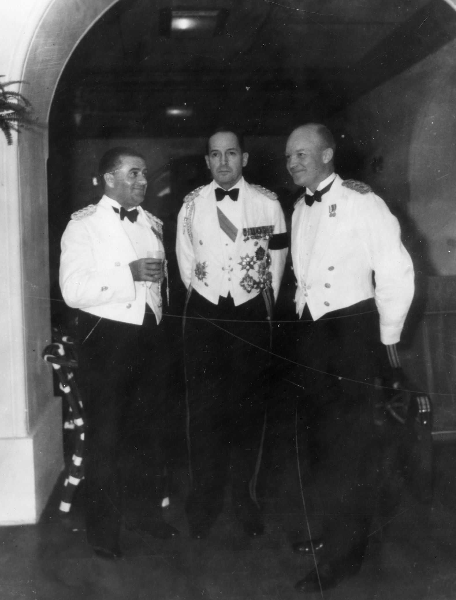 Black and white photo of Eisenhower, MacArthur, and Davis in formal dress.